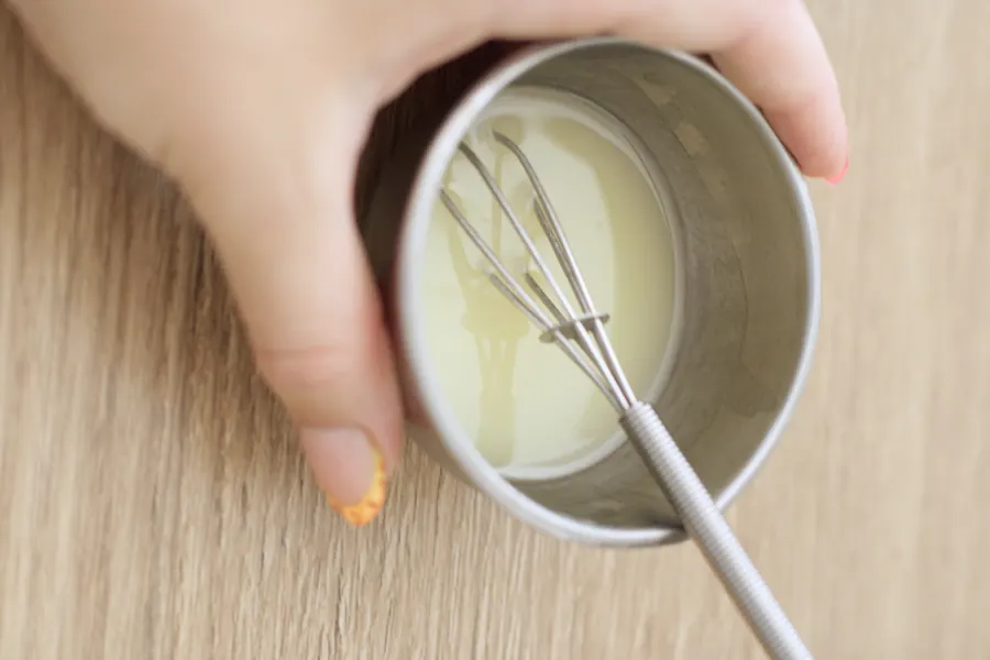 Mains réunies autour d’un bol de crème fraîchement émulsionnée
